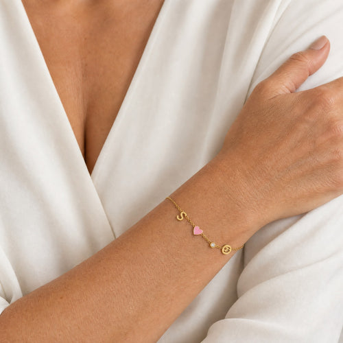 Initial, birthstone and zodiac charm bracelet worn on the wrist