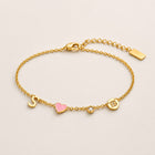 Gold charm bracelet with initial S, pink enamel heart, crystal birthstone and Cancer zodiac coin