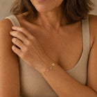 Woman wearing the dainty gold initial and zodiac bracelet
